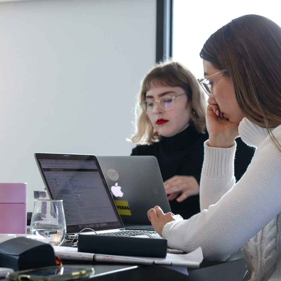 Woman reviewing economic charts on a laptop in an office